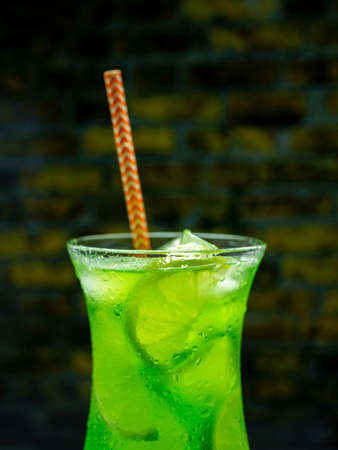 Green lemonade on the bar, green alcoholic cocktail, close-up drink with ice.の写真素材