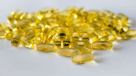 Yellow medical fish oil capsules, copy space.