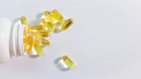 Top view Heap of capsules with oil close-up on white background, cod liver pills.の写真素材