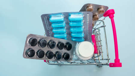 Pills and medicines in a supermarket basket from above view. The capsules are medicinal.の写真素材