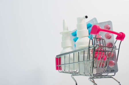 Health concept, closeup pills and medicines in a supermarket trolley, nasal spray for nose, spray for sore throat.の写真素材