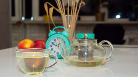 Hot tea in a cup close-up on the kitchen table. Herbal tea.