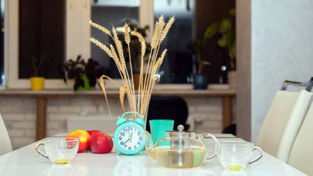Hot tea is brewed in a kettle on the kitchen table.