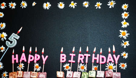 Happy birthday background with number  5. Copy space. Pink happy birthday candles on a black background. Happy birthday flower frameの写真素材