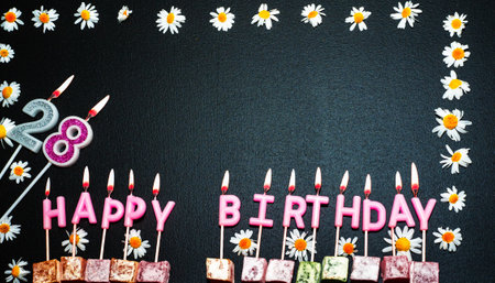 Happy birthday background with number  28. Copy space. Pink happy birthday candles on a black background. Happy birthday flower frameの写真素材
