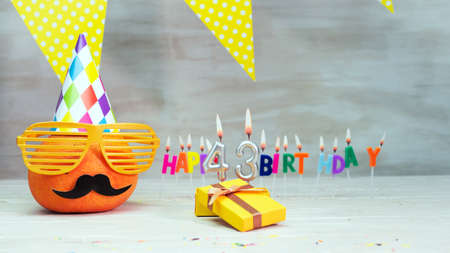 Happy birthday card with number 43. Copy space, beautiful birthday greeting character with mustache in glasses. Decorations with candles from numbers for a birthday.の写真素材