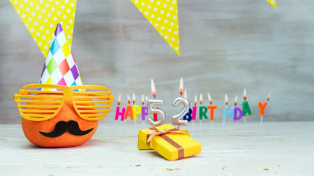 Happy birthday card with number 52. Copy space, beautiful birthday greeting character with mustache in glasses. Decorations with candles from numbers for a birthday.の写真素材