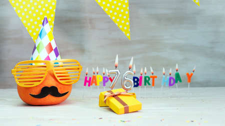 Happy birthday card with number 76. Copy space, beautiful birthday greeting character with mustache in glasses. Decorations with candles from numbers for a birthday.の写真素材