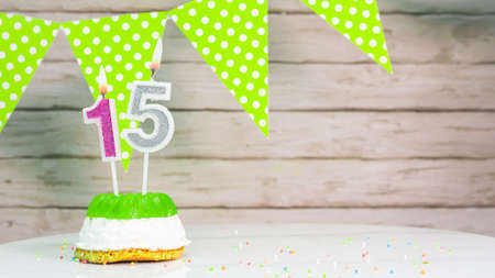 Beautiful festive background with the number 15 Ñwith a cake and lit candles, space saving for any holiday. Garland with birthday decorations for a postcard.Decorations are multi-の写真素材