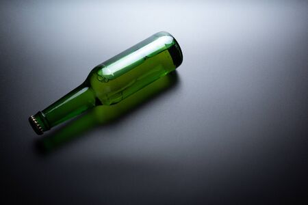 A bottle of green glass on a dark tableの写真素材