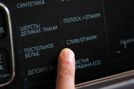 Close up of finger touching the screen of a smart home appliance.
