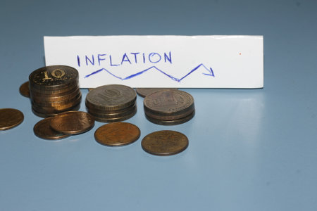 Coins and a note with the word inflation. financial concept.の写真素材