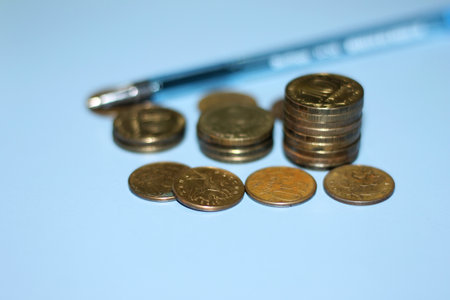 Coins and pen on a blue background. close-up.