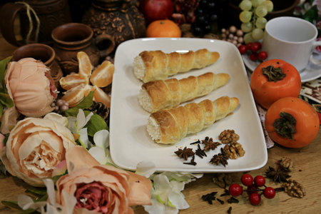 Coffee and croissants on a wooden table with flowers