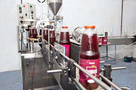 Bottles of juice on the conveyor belt in the factory.のeditorial素材