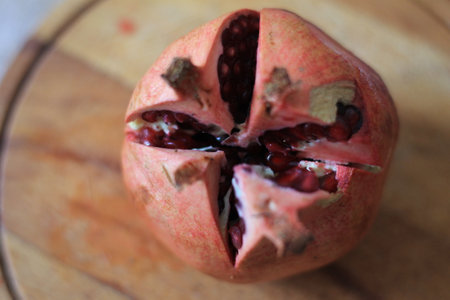 Ripe pomegranate fruit on a wooden board, close upの写真素材