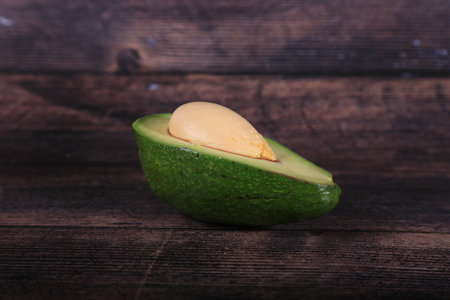 Avocado on a wooden background. Close-up, selective focus.
