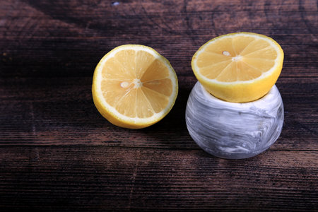 Lemon in a glass vase on a dark wooden background.の写真素材