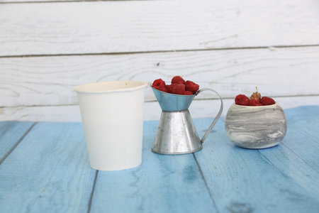 Cup of coffee and raspberries on a blue wooden backgroundの写真素材
