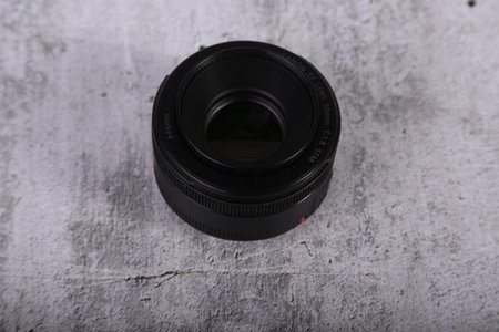 Camera lens on gray textured background. Shallow depth of field