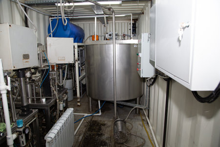 Modern brewery interior with equipment, pipes and tanks. Industrial background.