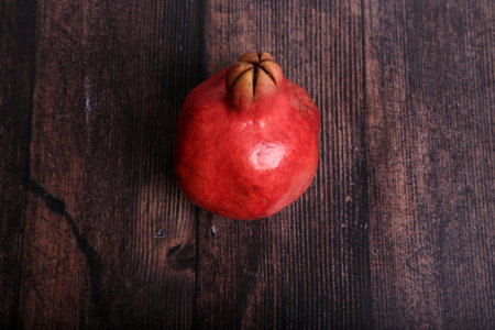 Ripe pomegranate fruit on wooden background. Toned.の写真素材