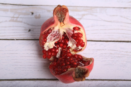 Ripe pomegranate fruit on wooden table close-upの写真素材