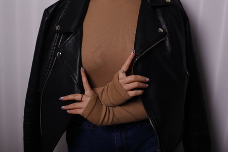 Close up of a young woman wearing black leather jacket and jeans.の写真素材