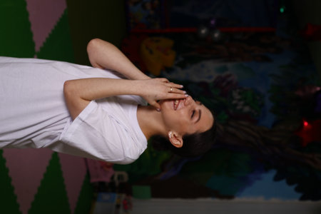 Young woman practicing thai chi in a room with colorful wall background