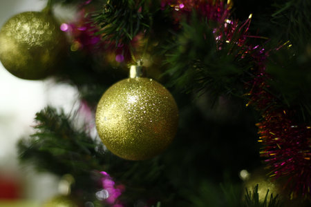Christmas tree decoration with golden baubles and tinsel on blurred backgroundの写真素材