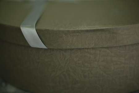 Close-up of green leather sofa with white ribbon. Selective focus.