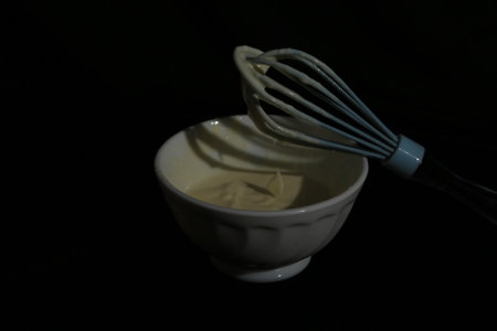 Bowl of mayonnaise with a whiskey on a black backgroundの写真素材