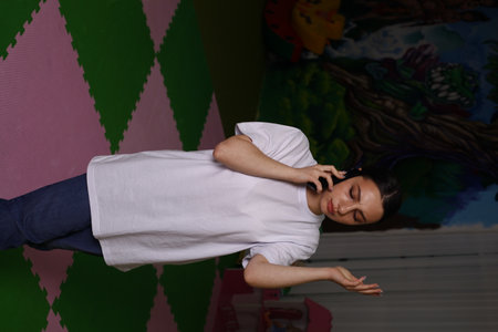A young girl in a white T-shirt is dancing in the studio.の写真素材