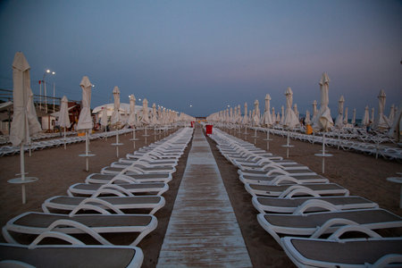 Beach umbrellas and sunbeds on the beach at nightの写真素材