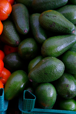 Avocado and tomatoes on a market stall. Selective focus.