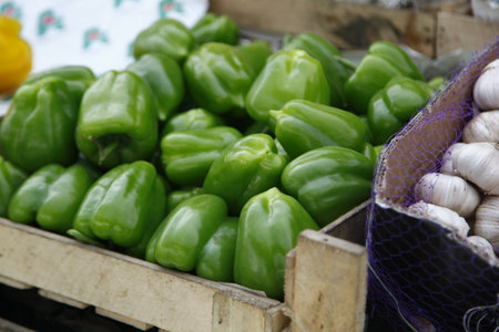 Green peppers and garlic on a market stallの写真素材