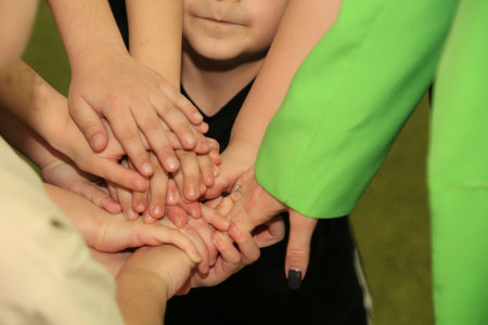 Children's hands in the form of a circle on a green backgroundの写真素材