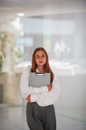 Portrait of a young businesswoman holding a folder in an office