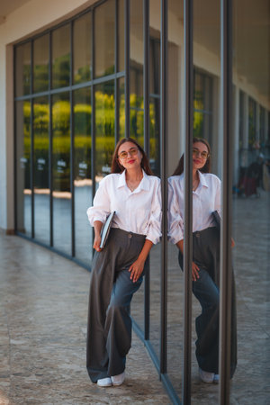 Portrait of a beautiful Asian woman wearing white shirt and black trousers.