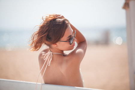 Portrait of a beautiful young woman in sunglasses on the beach.の写真素材