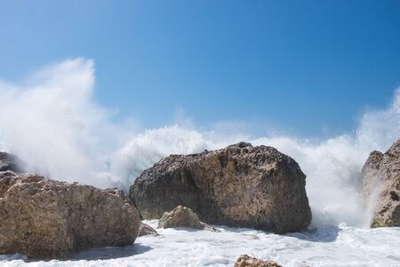 Stormy giant waves crash on the rocksの写真素材