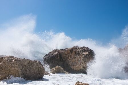 Stormy giant waves crash on the rocksの写真素材