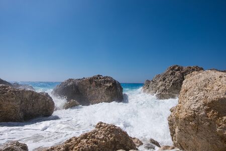 Stormy giant waves crash on the rocksの写真素材