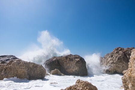 Stormy giant waves crash on the rocksの写真素材