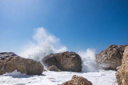 Stormy giant waves crash on the rocksの写真素材