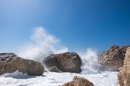 Stormy giant waves crash on the rocksの写真素材
