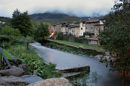 Ambroz River as it passes through the town of HervÃ¡s in Extremadura with the cloudy sky and dusk