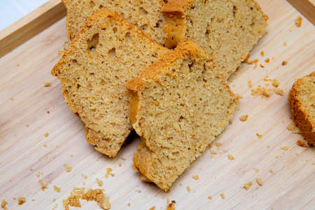 portions of sponge cake on a wooden tray with crumbsの写真素材