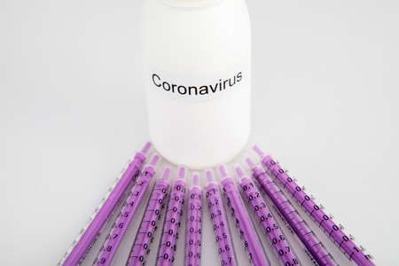 white bottle of coronavirus with syringes on white backgroundの写真素材