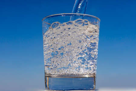 crystal glass full of water with the blue sky in the background